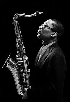 a black and white photo of a man playing a saxophone