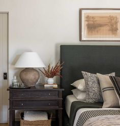 a bed sitting next to a night stand with two lamps on top of it