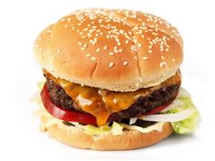 a cheeseburger with lettuce, tomato and onion on a sesame seed bun