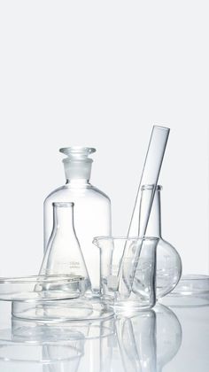 some glassware is sitting on a table with one empty beaker and the other filled with liquid