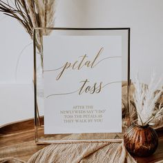 there is a sign that says petal toss on the table next to some feathers