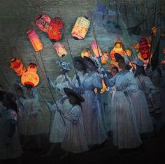 a group of women in white dresses holding lanterns