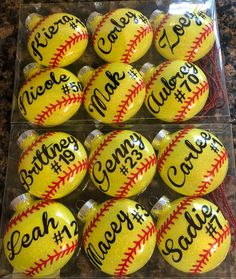 dozen baseballs with names on them are in a plastic box for sale at the store