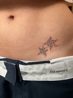 a woman's stomach with a small tattoo on it