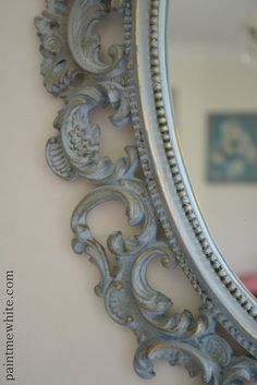 an ornate silver mirror hanging on the wall