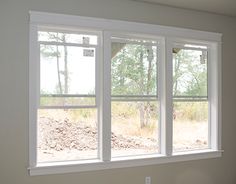 an empty room with three windows and no one in the room or there is anything outside