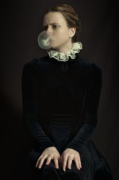 a woman in black dress sitting down with bubble coming out of her mouth and nose