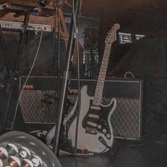 an electric guitar sitting on top of a stage next to amps and sound equipment