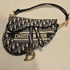 This Is An Authentic Christian Dior Oblique Embroidered Saddle Bag In Blue 2019. This Saddlebag Is Made Of Navy On Beige Dior Monogram Canvas With Velvet Trim And "Christian Dior" Embroidered On The Front. The Bag Features A Matching Looping Handle And Brass Hardware, And The Flap Opens To An Unlined Fabric Interior Dior Her, Doudoune The North Face, Christian Dior Bag, Tas Bahu, Dream Bag, Dior Saddle, Embroidered Canvas, Outfit Ideas Winter, Transition Outfits