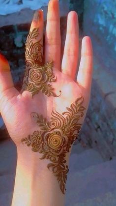 a woman's hand with henna tattoos on it