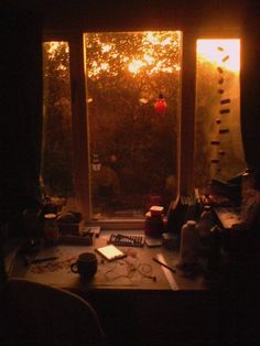 a room with a desk and window that is lit by the sun's rays