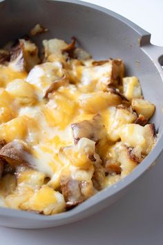 a casserole dish with cheese and mushrooms in it on a white table top