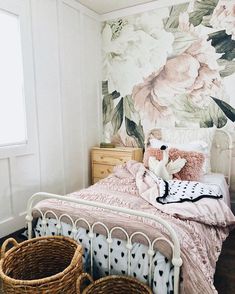 an instagram photo of a bed with flowers on the wall and two baskets next to it