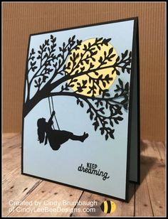 a card with a silhouette of a person swinging on a tree