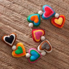 three small felt hearts on a wooden surface