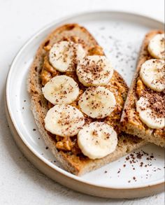 two slices of toast with bananas on top and cinnamon sprinkled on the side