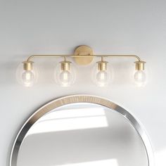 three lights on the wall above a mirror and light fixture in a room with white walls