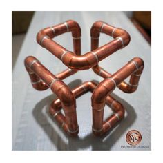 a group of copper pipes sitting on top of a white table next to each other