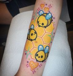 a yellow tattoo with bees on it's arm and hearts in the middle, surrounded by honeycombs