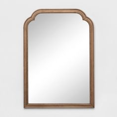 a wooden mirror hanging on the wall