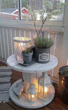 a white table topped with potted plants on top of a wooden floor next to a window