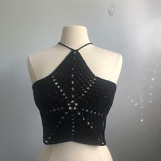 a white mannequin wearing a black crochet halter top