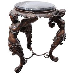 an ornately carved table with marble top and metal legs, on display against a white background