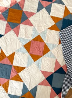 two quilts are laying on the floor next to each other and one is blue, pink, orange and white