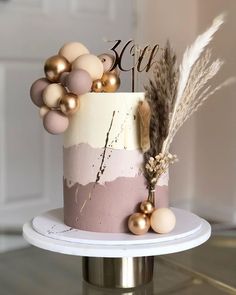 a pink and white cake with gold decorations