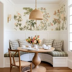 a breakfast nook with flowers on the wall and bench in the corner next to it