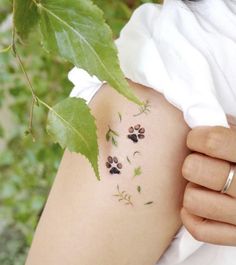 a woman with tattoos on her arm and paw prints on the back of her shoulder