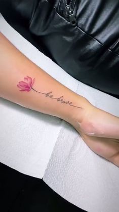 a woman's arm with a tattoo that says be brave and a flower on it