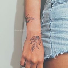 a woman's hand with a tattoo on it, holding onto the arm of another person