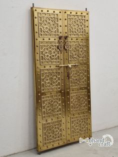 an intricately designed metal door on the side of a building with no people around it