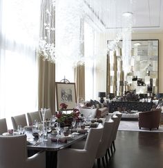 an elegant dining room with chandelier hanging from the ceiling and table set for eight