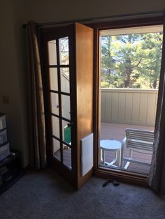 an open door leading to a patio with chairs