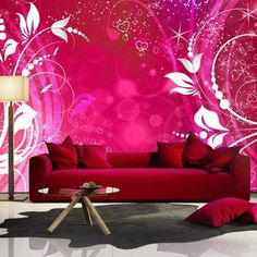 a red couch sitting in front of a pink wall with swirls and stars on it