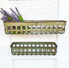 two wooden baskets with flowers in them hanging on a door handle, one holding lavenders