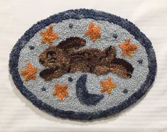 a patch with an image of a cat sleeping on the moon, stars and crescent