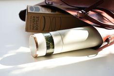 a pair of glasses sitting on top of a bag next to a book and sunglasses