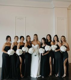 a group of women standing next to each other holding bouquets in front of them