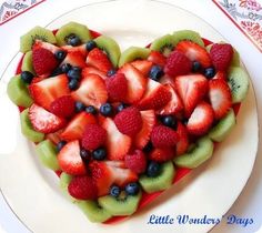 a heart shaped fruit salad on a plate