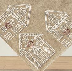 three white embroidered napkins sitting on top of a wooden table