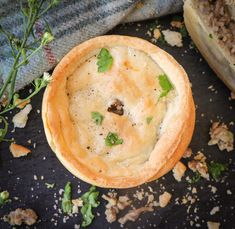 a baked dish with herbs and seasoning in it sitting on a table next to a blanket