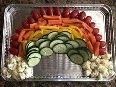 vegetables arranged in the shape of a rainbow on top of cauliflower and carrots