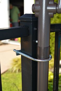 a metal pole with a handle attached to it next to a grass covered yard area