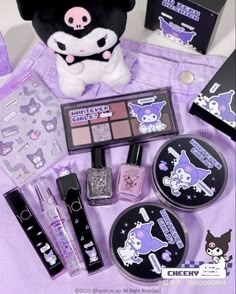 various items are displayed on a purple cloth with a stuffed animal in the background, including makeup and nail polish