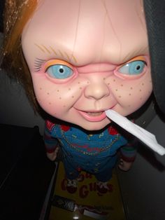 a close up of a doll with an electronic toothbrush in it's mouth