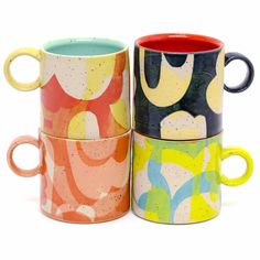 three different colored coffee mugs sitting next to each other