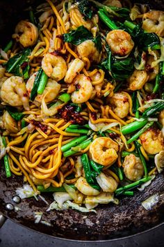 stir fried noodles with shrimp and vegetables in a skillet